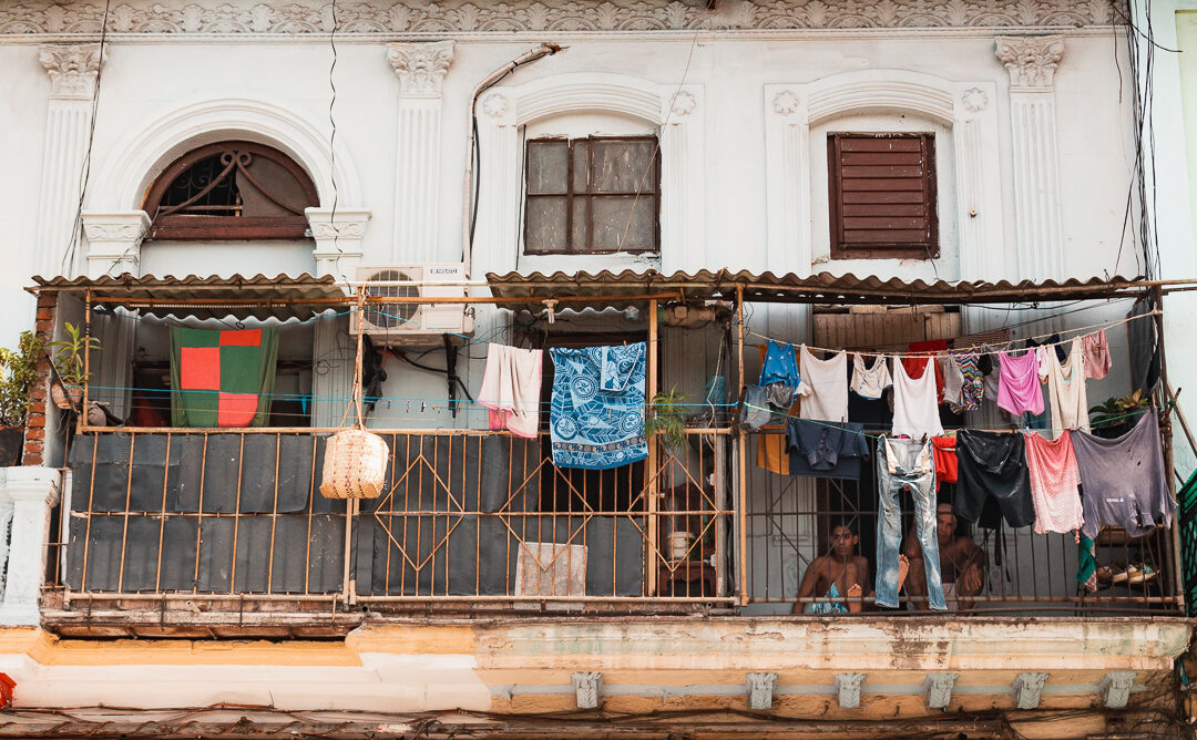 Laundry hanging from a balcony above a street in Havana